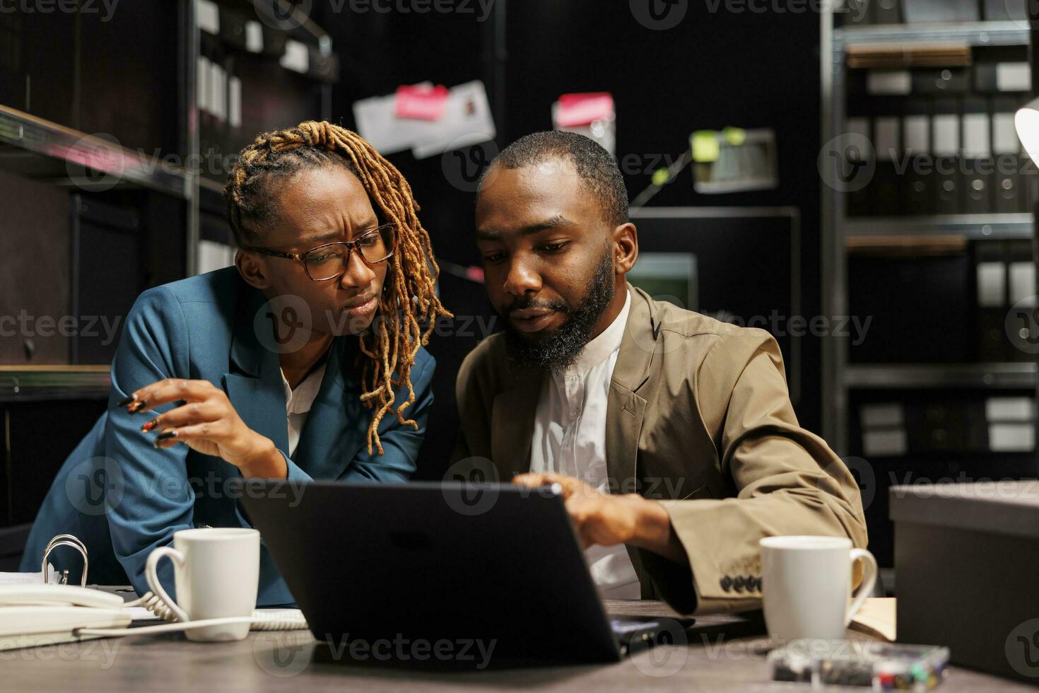 African american criminologists colleagues conducting investigation research in detective office. Man and woman law eneforcement professionals studying crime case on laptop together photo