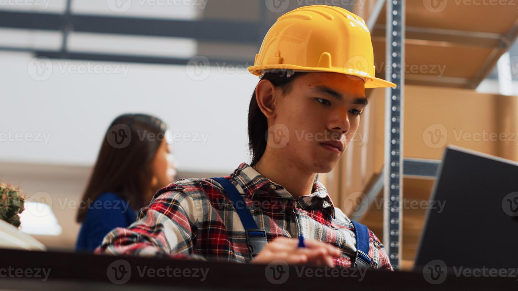Team of asian people working in storage room with goods, preparing products in boxes for retail store distribution. Employees checking stock of merchandise in warehouse space. Handheld shot. photo