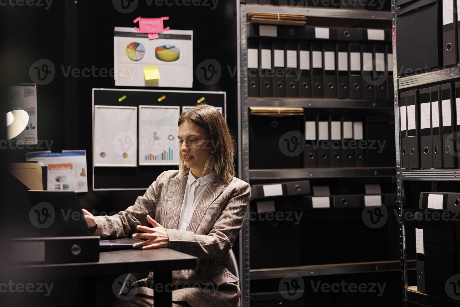 Corporate manager working at administrative record, analyzing business paperwork in arhive room. Caucasian businesswoman checking bureaucracy report, searching accountancy files. Depository concept photo