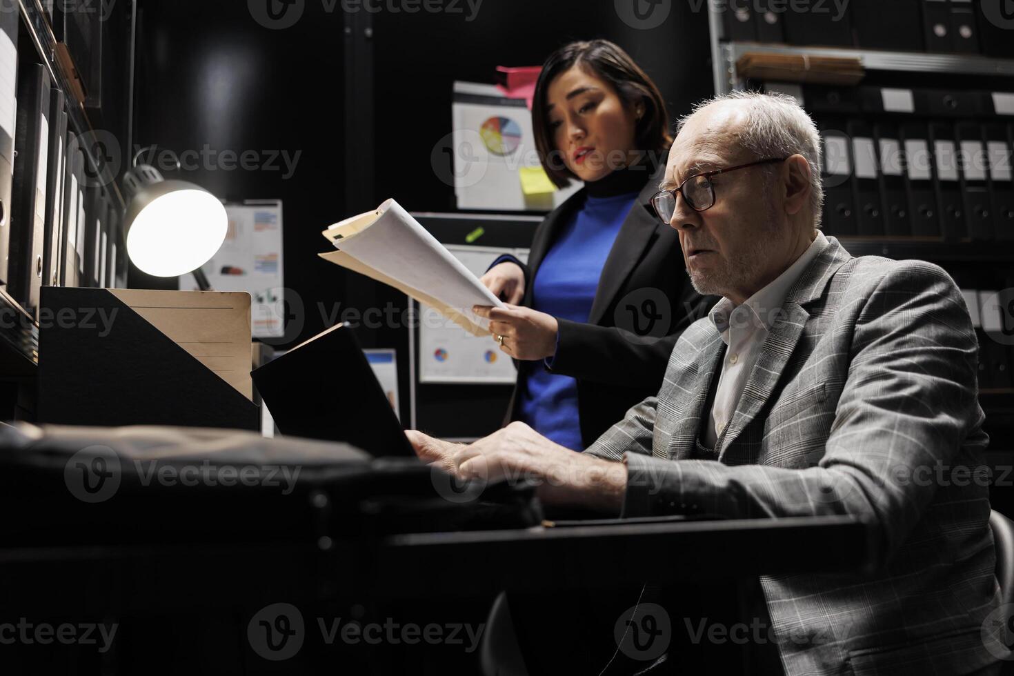 Business employees brainstorming accountancy data analysis report using laptop and statistics document records. Archive file room filled with cabinet, folders and flowcharts photo