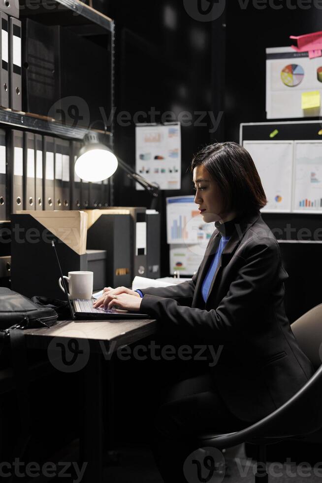 Professional administration businesswoman inserting bookkeeping administrative data paperwork on laptop. Accountancy storage room office filled with folders and diagram charts photo