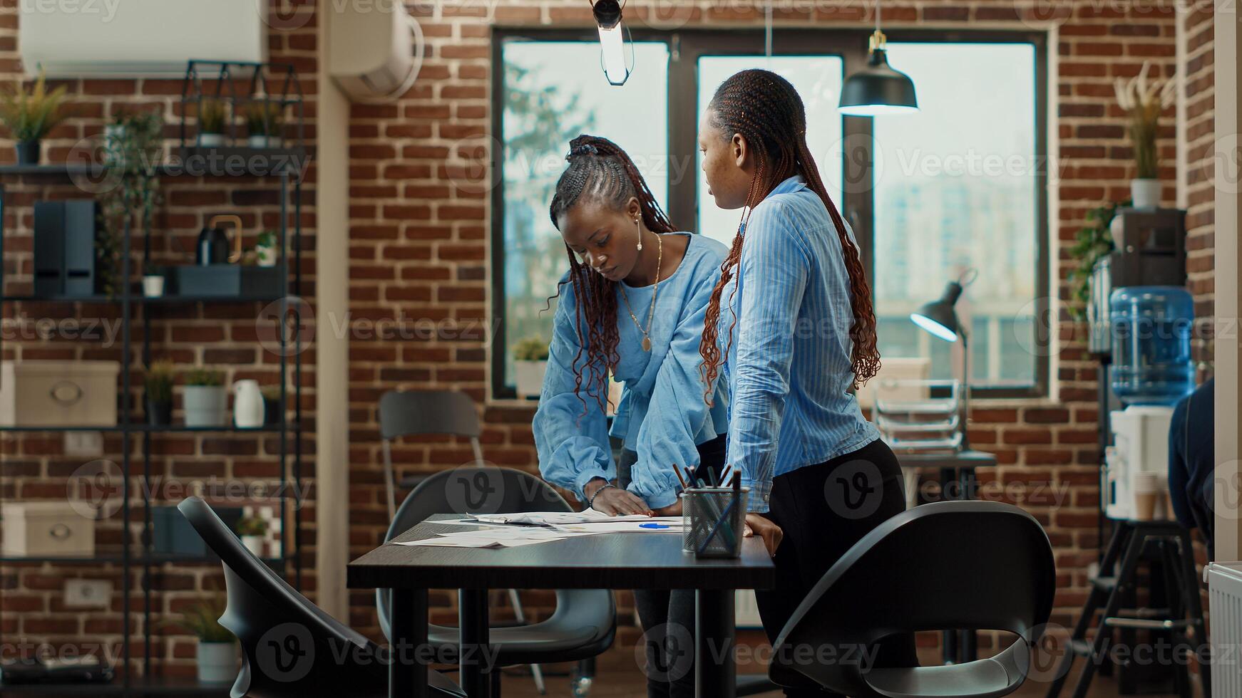 Women employees reading data analytics on boardroom table, looking at official reports documents to find new business solution. Team of workers meeting to examine statistics, increase profit. photo