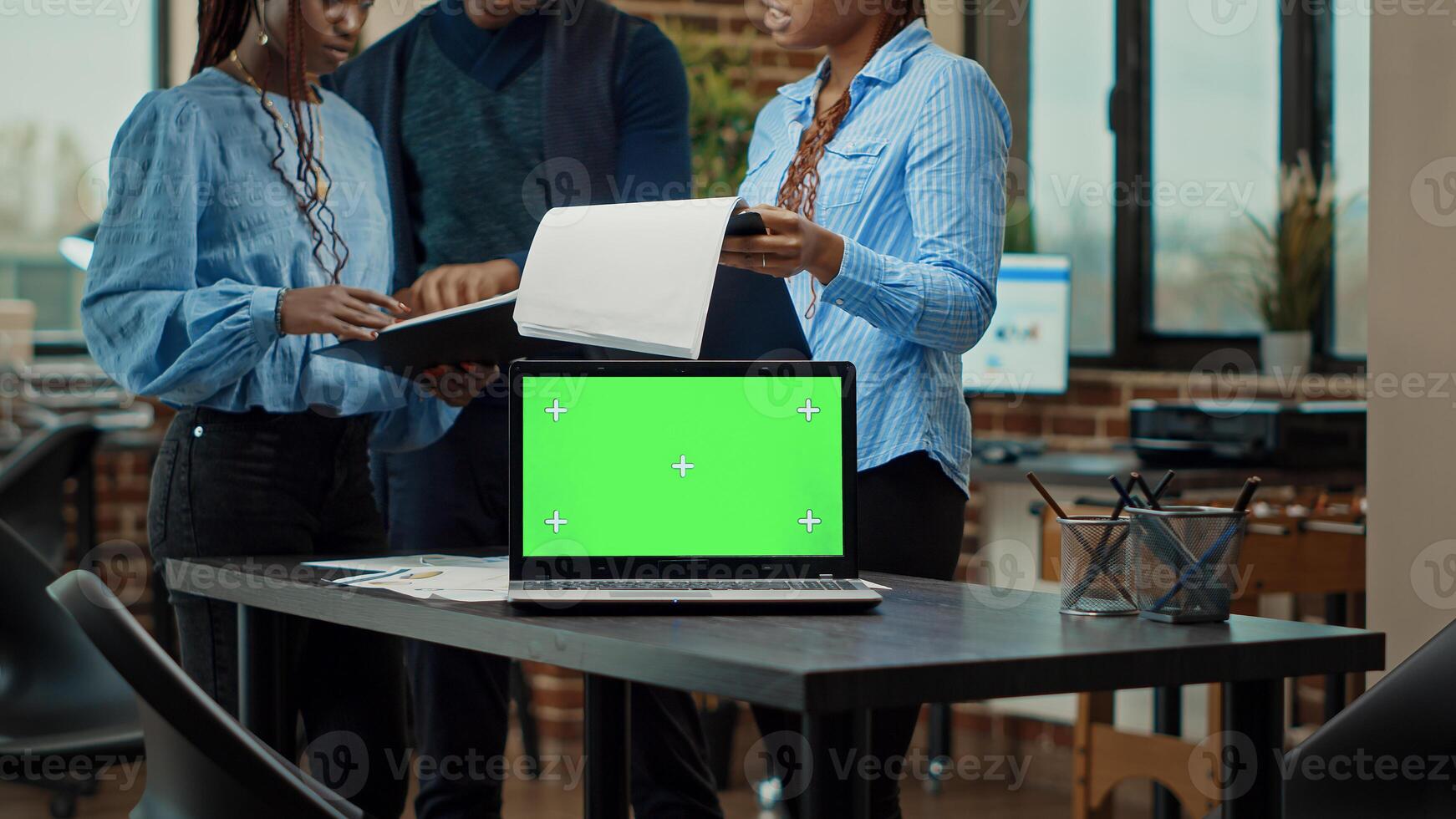 empleados equipo analizando documentos utilizando paisaje verde en computadora portátil, personas trabajando con aislado monitor en trabajo colaborativo espacio. colegas planificación nuevo estrategia con blanco croma llave Bosquejo pantalla. foto