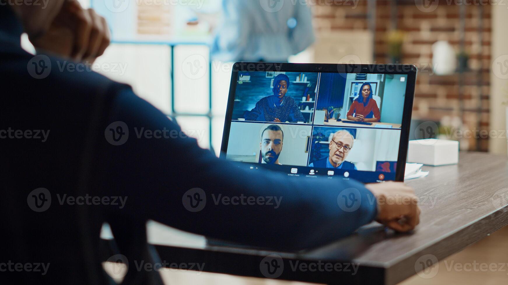 Young man meeting with business people on online video call, attending teleconference in company office space. Male employee using remote videoconference, videocall internet chat on laptop. photo