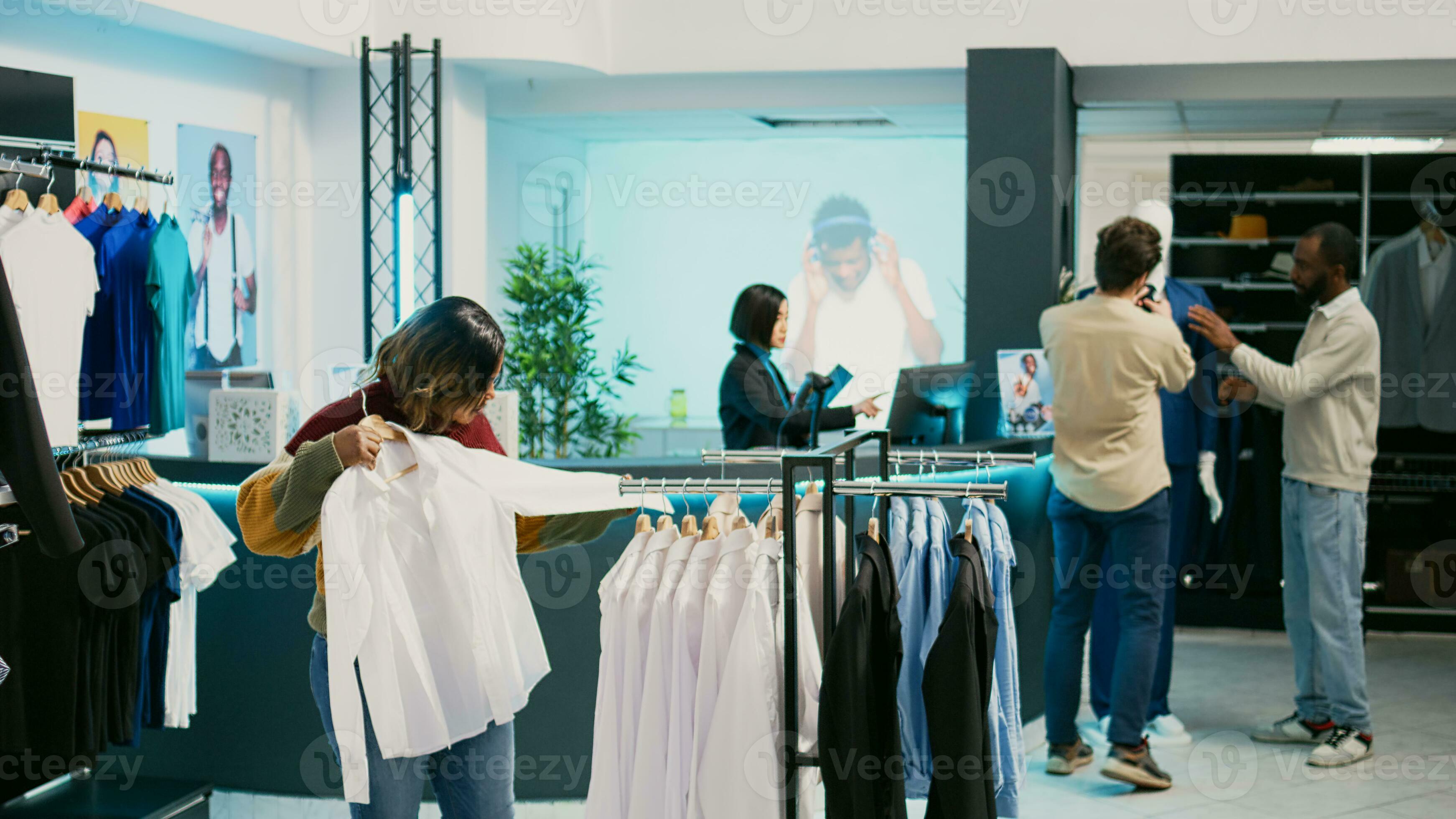 Female customer looking at merchandise in clothing store, shopping for new  trendy collection. Young woman checking clothes hanging in department store,  modern fashion boutique. 32624194 Stock Photo at Vecteezy