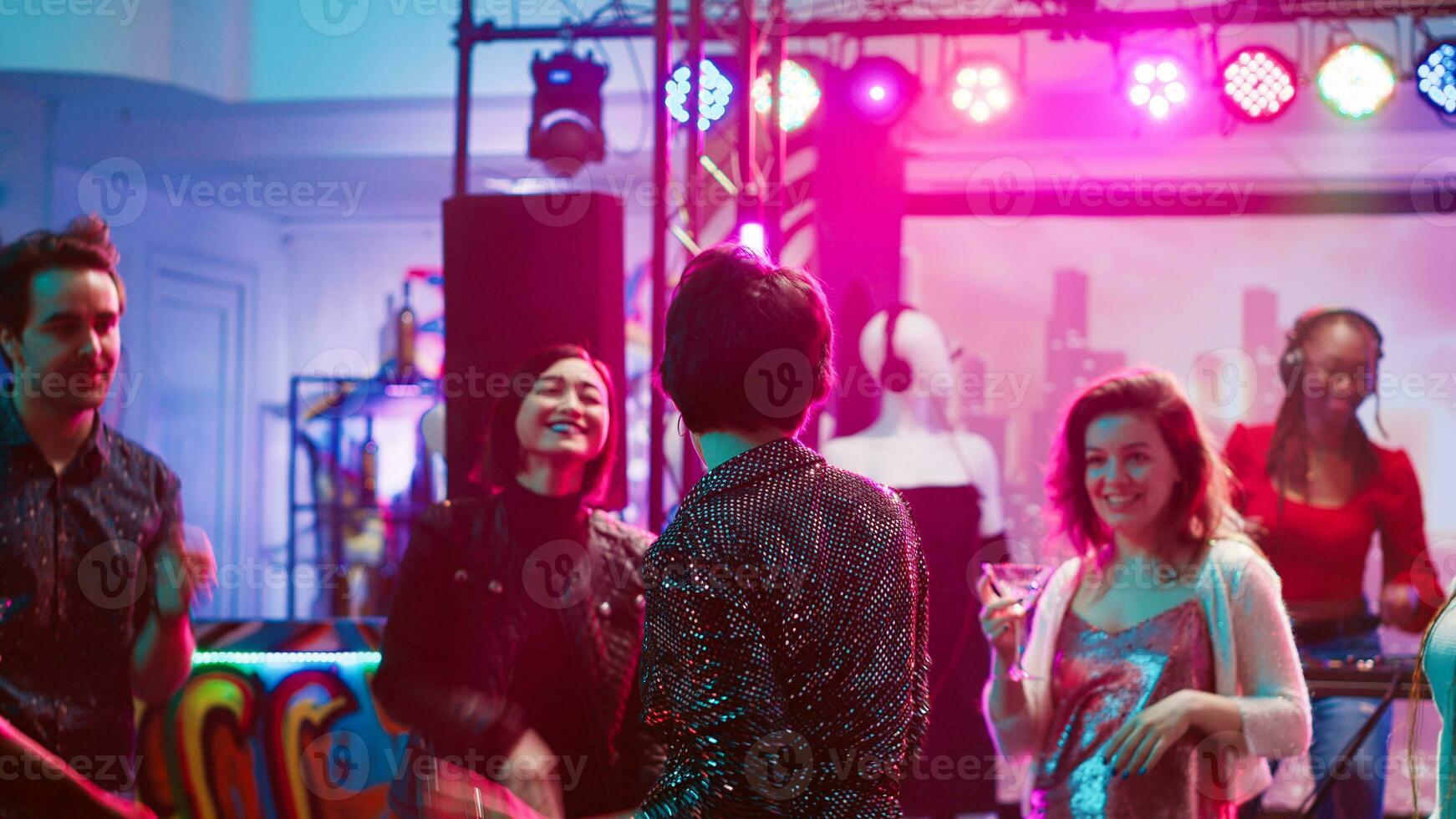 Funky people dancing at discotheque with live disco music, partying together on dance floor. Young group of friends enjoying nightlife at club, going clubbing for entertainment. Tripod shot. photo