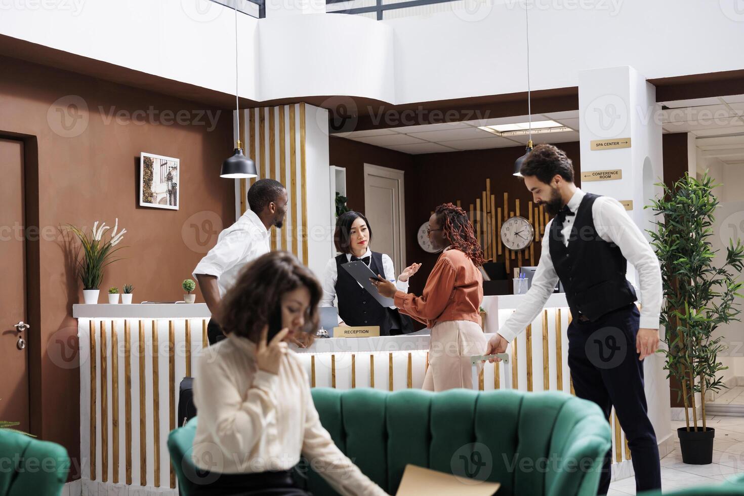 Couple filling in registration forms at reception desk, doing check in upon their arrival at hotel. Man and woman preparing to see room accommodation at front desk, luxury resort. photo