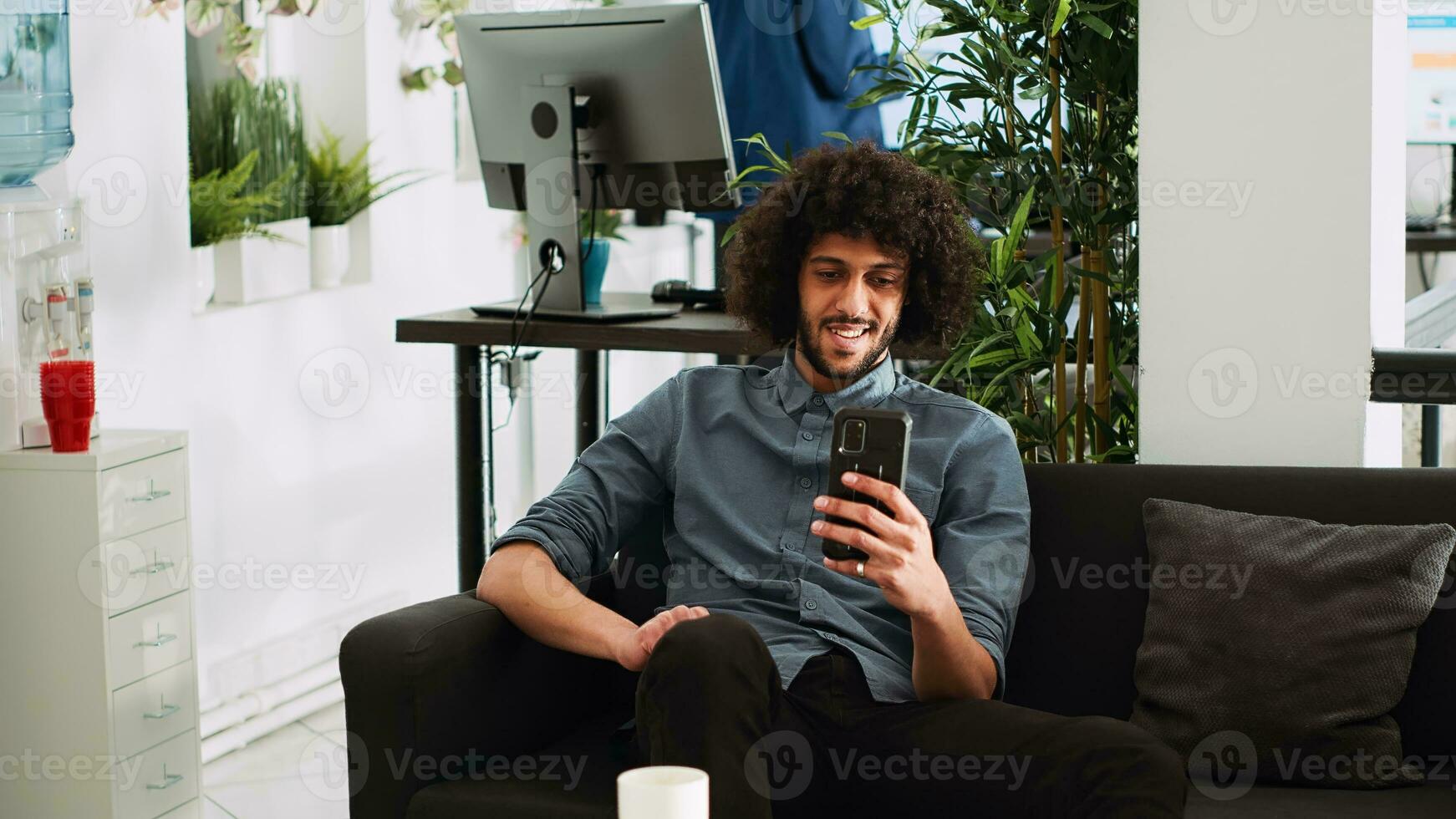 Businessman on work break checking phone, browsing webpage in coworking space. Small business employee using smartphone before working on analytics plan for startup presentation. photo