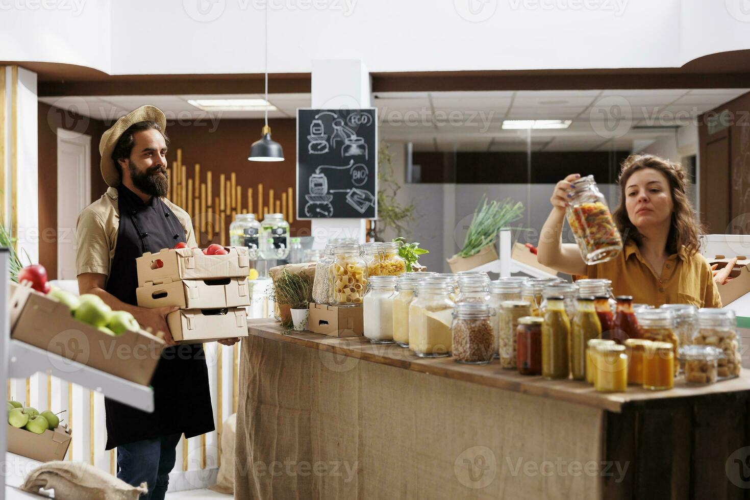 Consciously living farmer bringing crates full of vegetables from his own garden to zero waste supermarket. Supplier restocks local neighborhood store with nutritious preservatives free food items photo