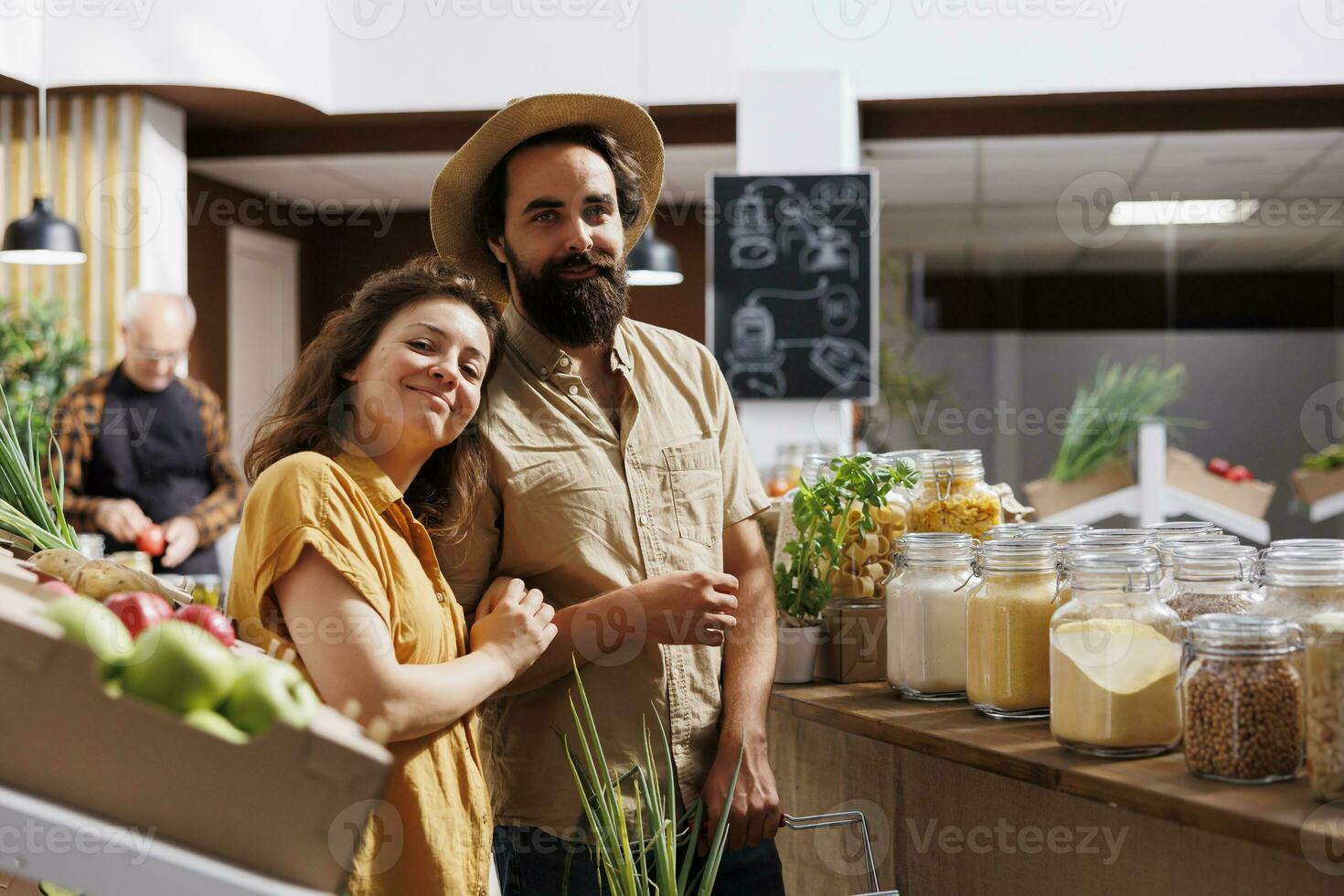 Man and woman shopping in zero waste store, looking for healthy locally sourced bulk products. Consciously living couple buying pantry staples from local neighborhood shop photo