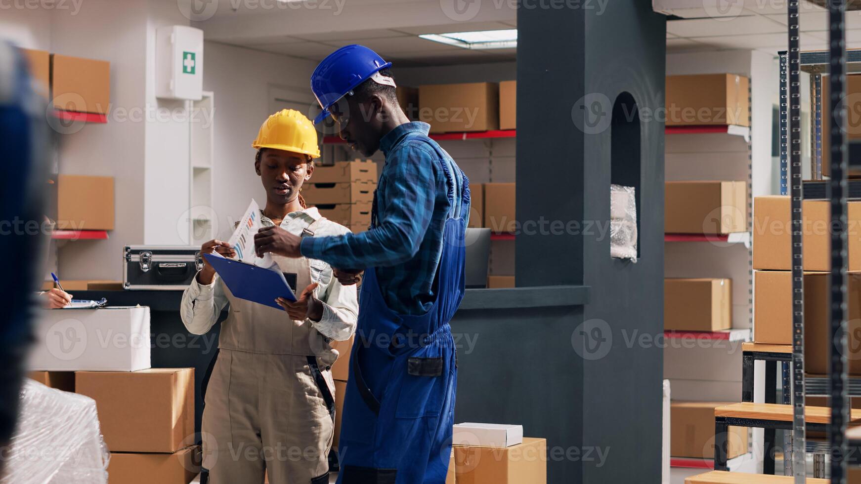 Diverse people working with merchandise in boxes, planning order distribution for goods shipment. Two depot employees looking at packages filled with stock merchandise. Tripod shot. photo