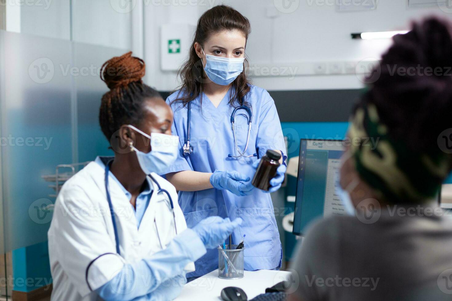 enfermero y médico ofrecimiento paciente médico Guia en clínica oficina durante cita. general facultativo en antibacteriano protector máscara y guantes prescribir medicina en botella a mujer foto