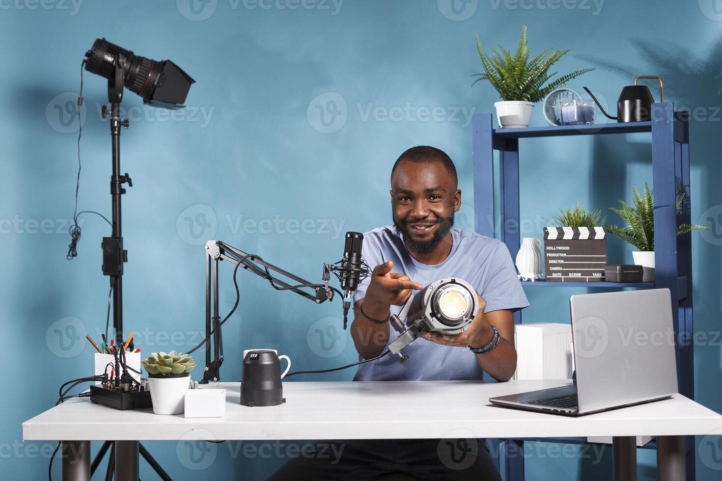 African american blogger testing and reviewing photography studio lightning equipment while live streaming. Photographer showing professional gear and recording video for online channel photo