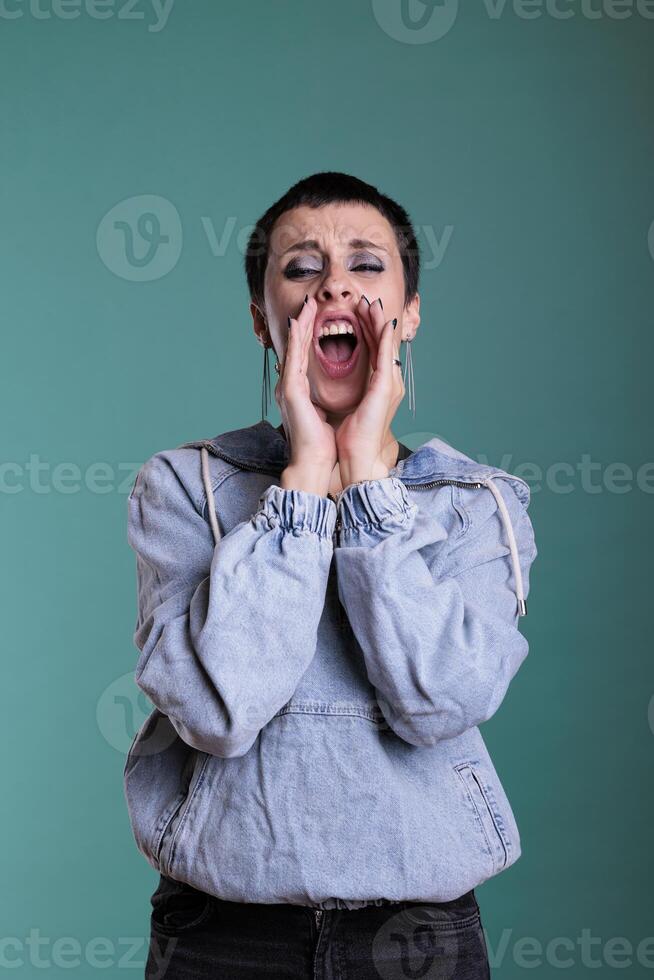 retrato de estresado enojado caucásico hembra teniendo mental Descompostura en estudio en pie terminado aislado antecedentes. infeliz agresivo mujer gritando mientras mirando a cámara, negativo facial expresión foto