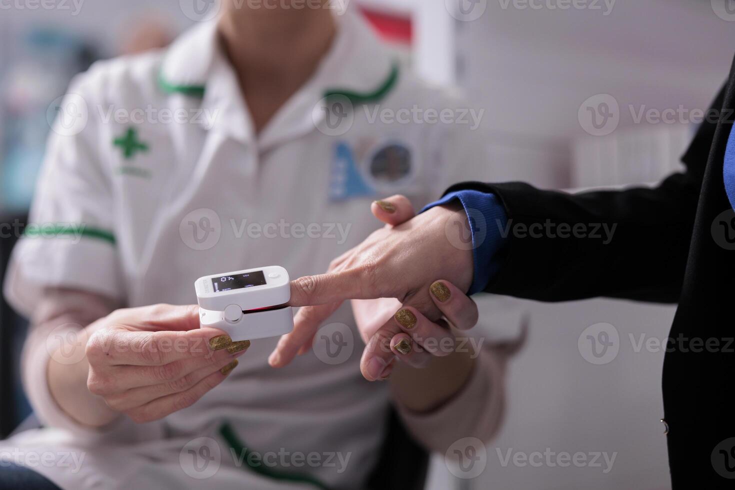 Apothecary worker putting pulse oximeter on patient finger for cardiology disease diagnosis. Pharmaceutical assistant examining drugstore client heart health and measuring oxygen level in blood photo