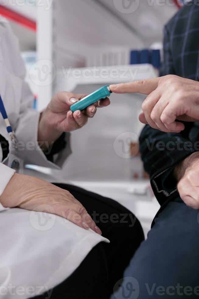 Chemist measuring patient blood sugar level for insulin test with glucometer medical instrument. Senior man visiting apothecary for diabetes diagnostics and healthcare checkup photo