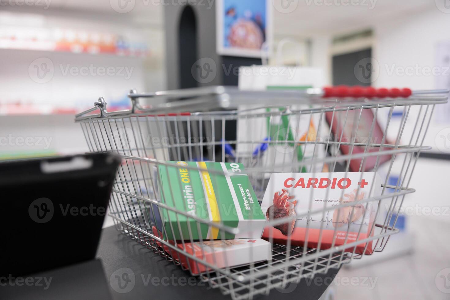 Pharmacy shopping basket filled with cardiology pills and vitamins packages standing on counter desk, waiting to customers to come and buy. Drugstore had a wide selection of medical products photo