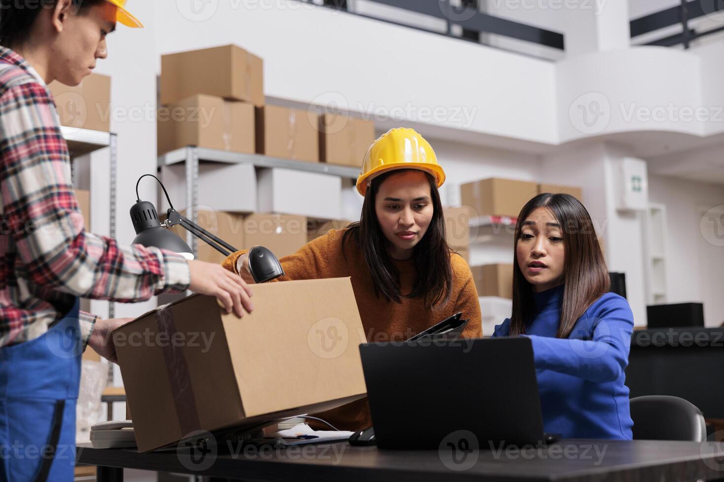 Shipment service employees managing online order shipment in warehouse. Asian package handler giving cardboard box ready for shipment to delivery operators team in retail storehouse photo