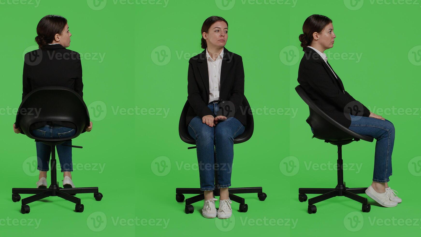 Caucasian businesswoman wearing suit and sitting on chair, waiting in preparation over full body green screen backdrop. Young adult working as corporate employee being positive in studio. photo