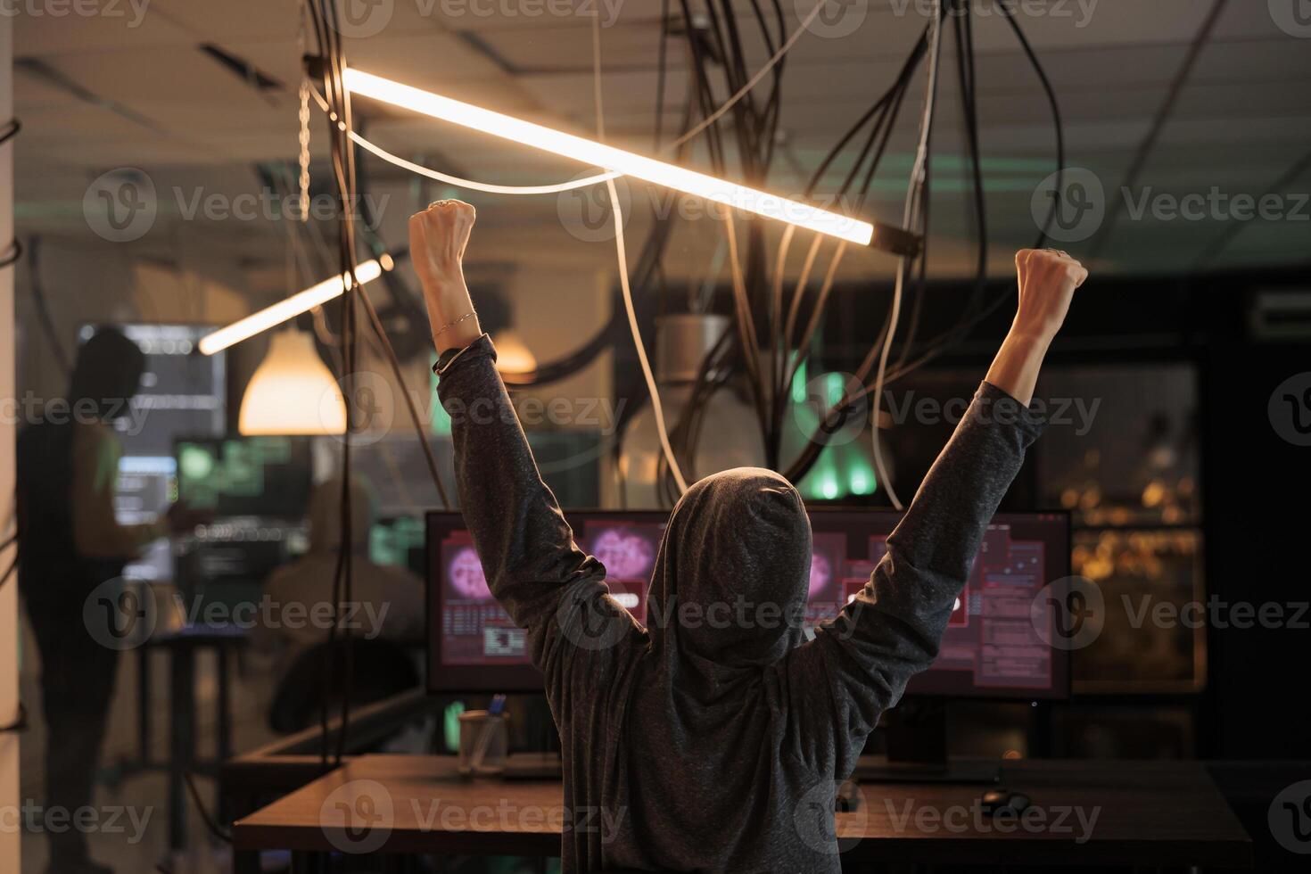 Happy thief celebrating security breach and hacking computer system, successful mysterious hacker breaking into server. Cyberriminal feeling satisfied about hacking achievement and victory. photo