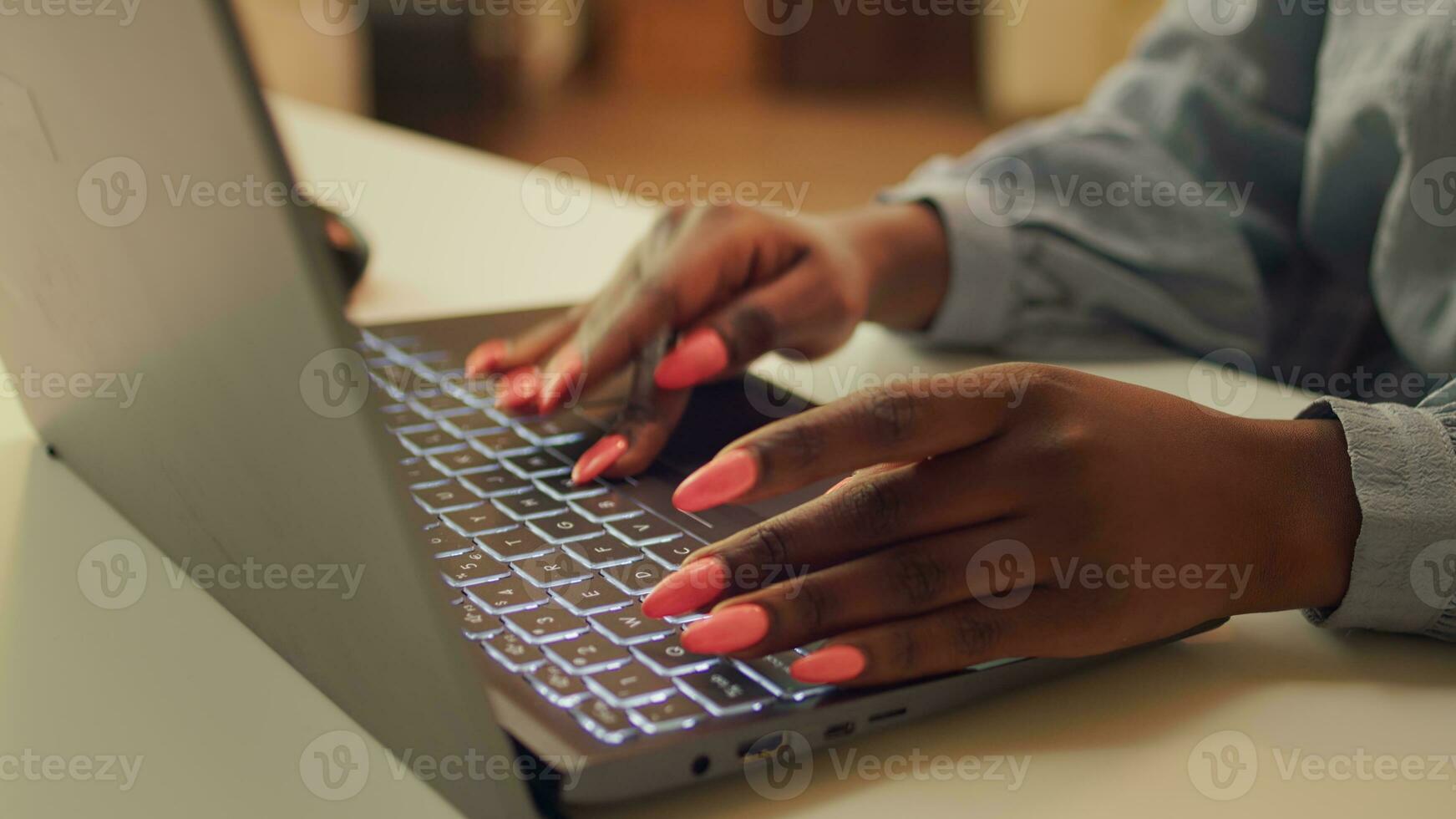 Woman typing information on laptop, working to solve web project tasks at home. African american blogger writing story line for teleworking job, self employed developer. Close up. photo