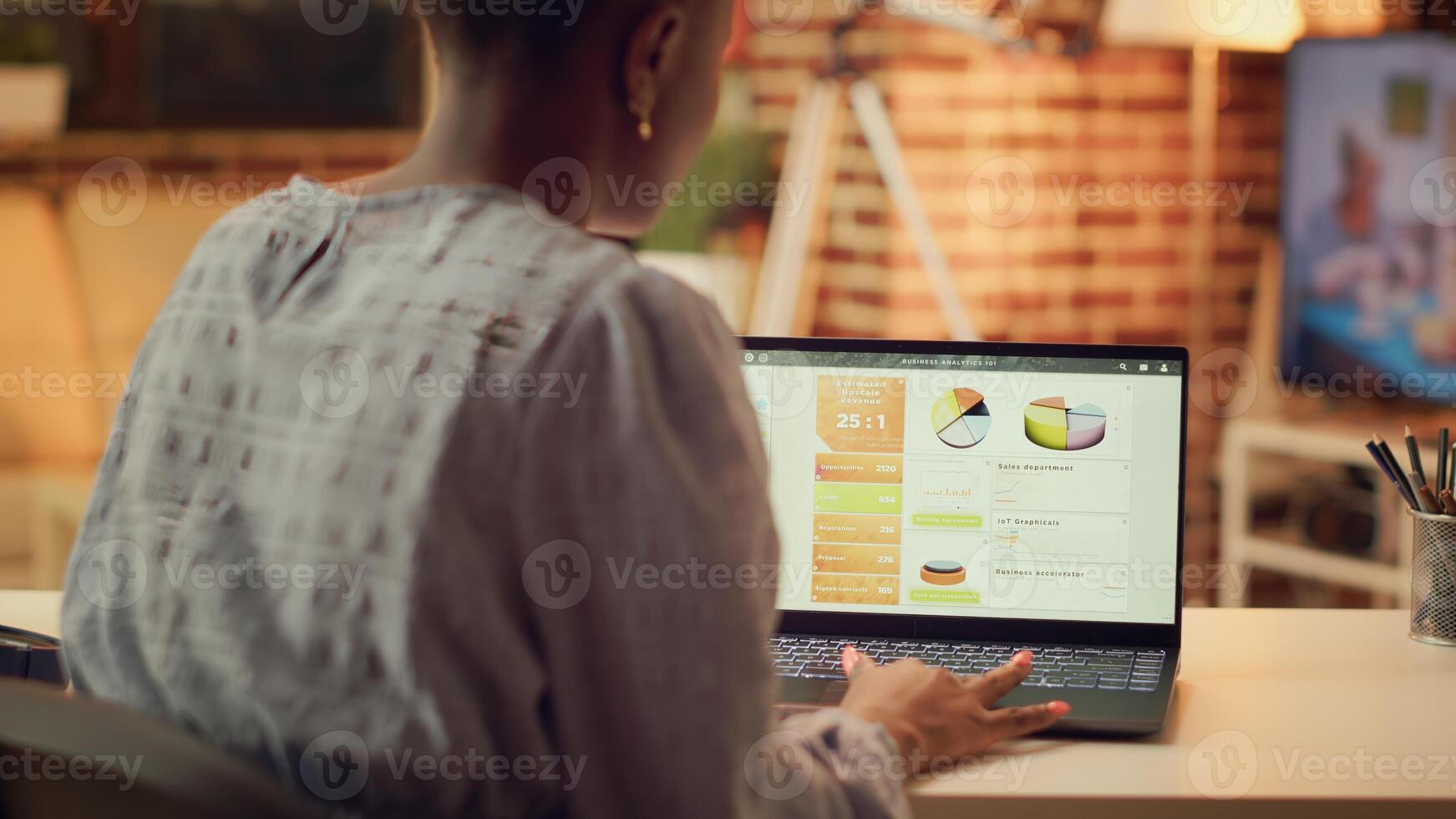 Teleworker researching online data, preparing to solve new freelancing tasks for marketing advertisements. African american person offering internet services remote from home at sunset. photo