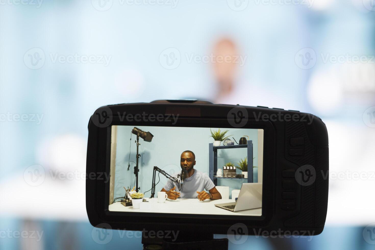 Blogger streaming while creating digital content and recording video with professional camera closeup. African american vlogger recording video and broadcasting live for podcast photo