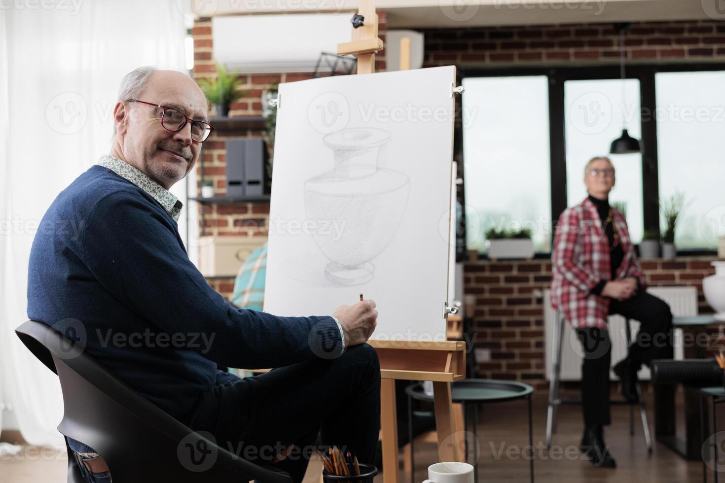 creativo aficiones para adultos sonriente maduro hombre sentado a Arte estudio espacio, desarrollando creatividad en Jubilación, aprendizaje a dibujar después 50 años. personas expresando sí mismos mediante dibujo foto