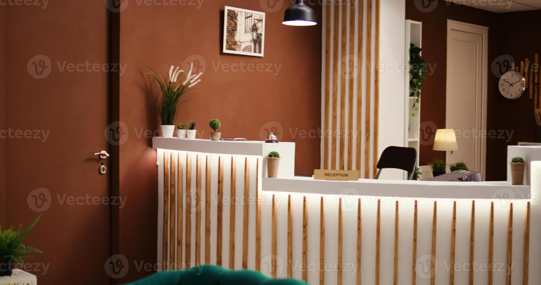 Empty stylish modern hotel lounge interior with cozy furniture and warm fireplace ready to welcome visitors. Travel accommodation resort lobby with check in front reception desk photo