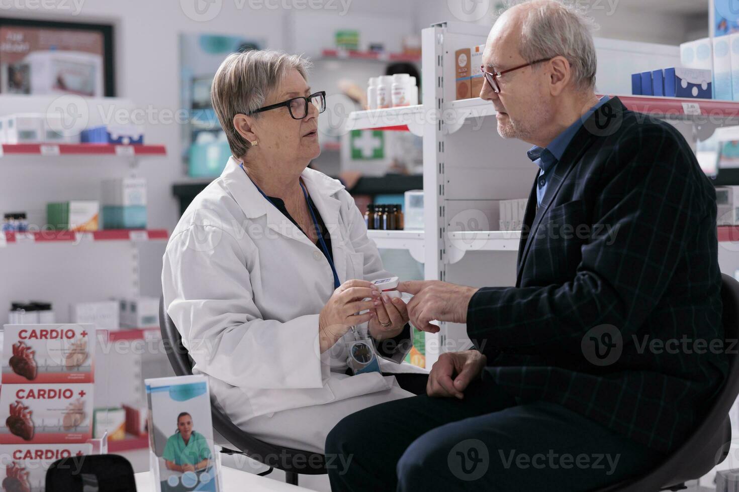 Elderly pharmaceutical assistant measuring customer arterial oxygen saturation level in pharmacy shop. Medical worker using cardiology instrument on old patient fingertip to examine heart health photo