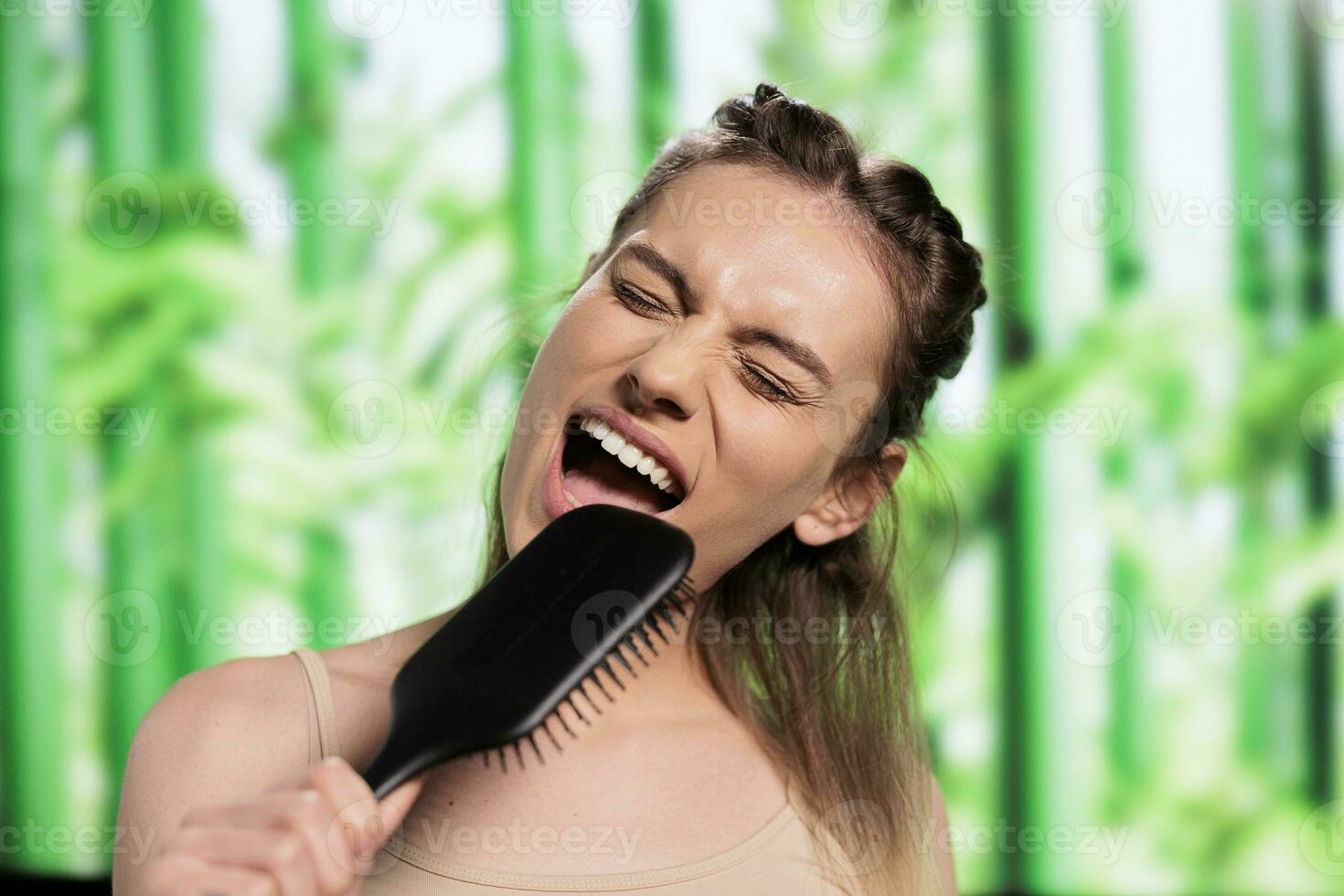 atractivo mujer haciendo peinado y utilizando cepillo para el pelo como micrófono. joven hermosa caucásico dama escuchando a música, fingiendo a canta en peine y cepillado rubia pelo foto