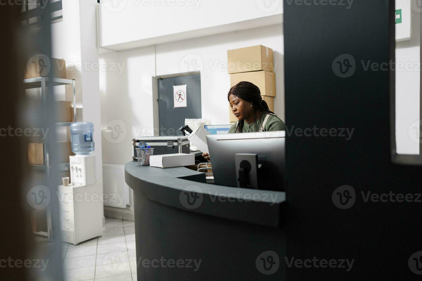 Small business manager analyzing storehouse logistics on computer, working at merchandise inventory report in storage room. Warehouse worker preparing customers orders for shipping photo