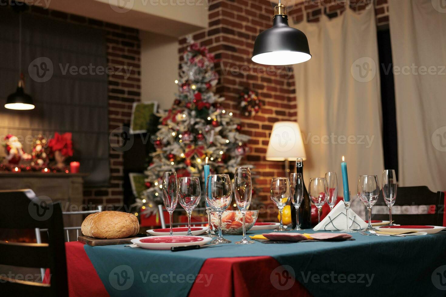 Christmas dinner set up for family feast on december winter holiday at dining room in cozy settings. Alcohol glasses, food dishes, and xmas decorations creating lovely festive atmosphere photo