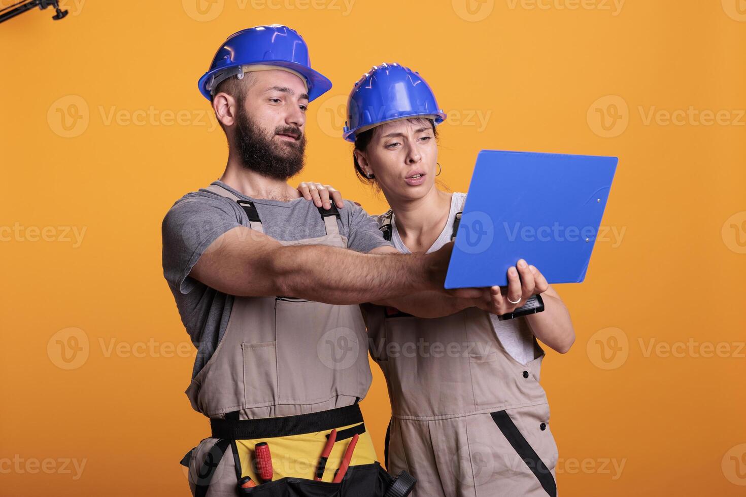 Team of renovators analyzing papers on clipboard, taking notes of construction measurements. Builders looking at files with building or renovating information, engineering skills. photo