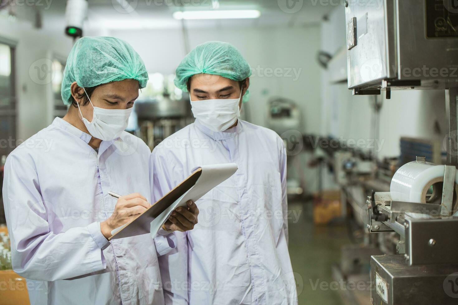Male workers working together in drinks beverage factory with hygiene clean safety. worker check product quality process. photo
