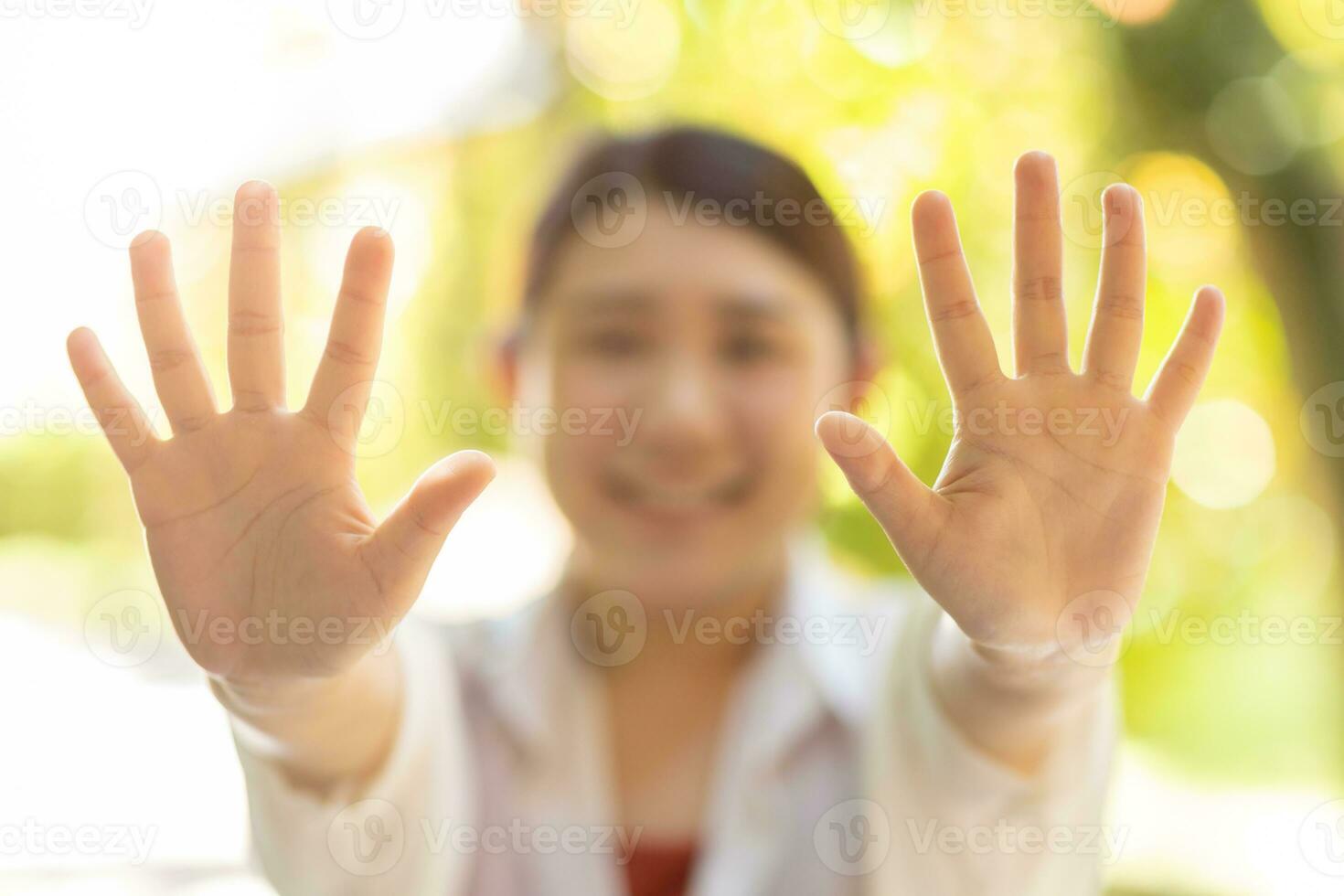 closeup happy woman showing open palm two bare hand 10 fingers. help support giving volunteer people. stop hands on blur green natural background photo