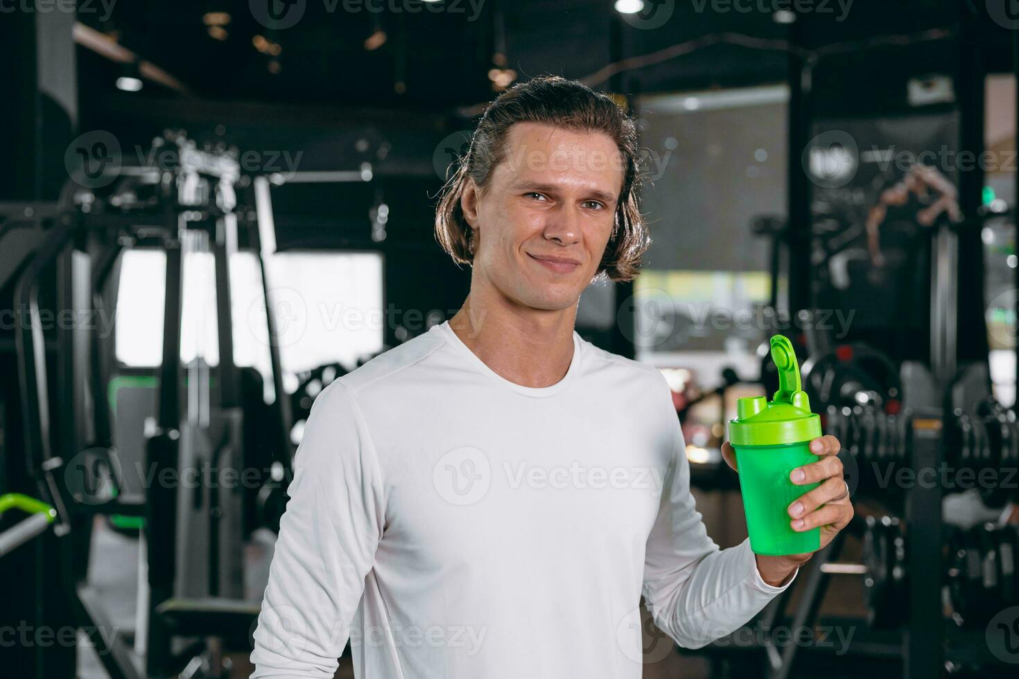 healthy sport man with whey shaker bottle. happy drinking whey protein for muscle strength mass gain and low fat beverage meal in gym fitness photo