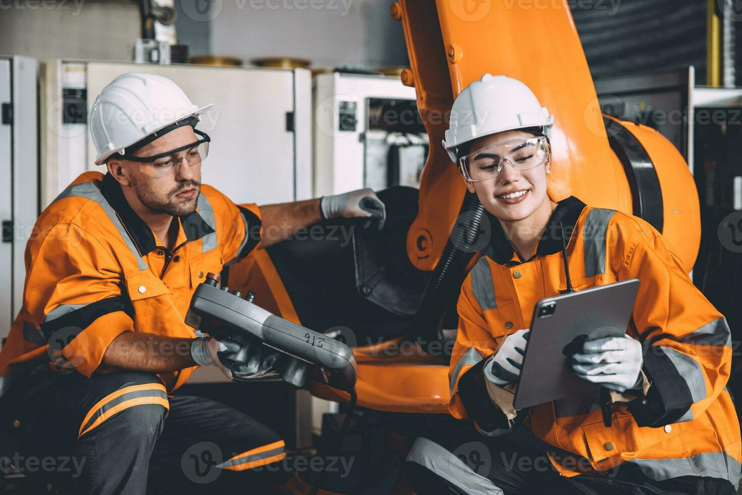 Happy engineer team working in modern automation factory with welding robot arm control training operation. women worker machine learning industry technology photo