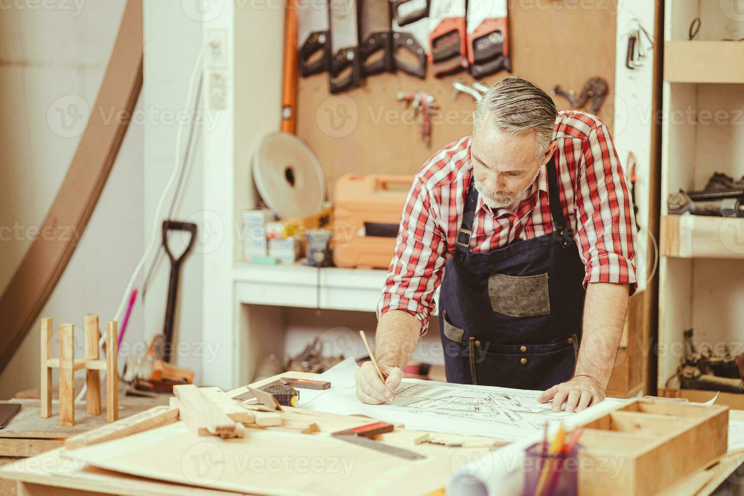 Senior professional engineer architect male working design drawing floor plan home furniture and renovate in workshop. photo
