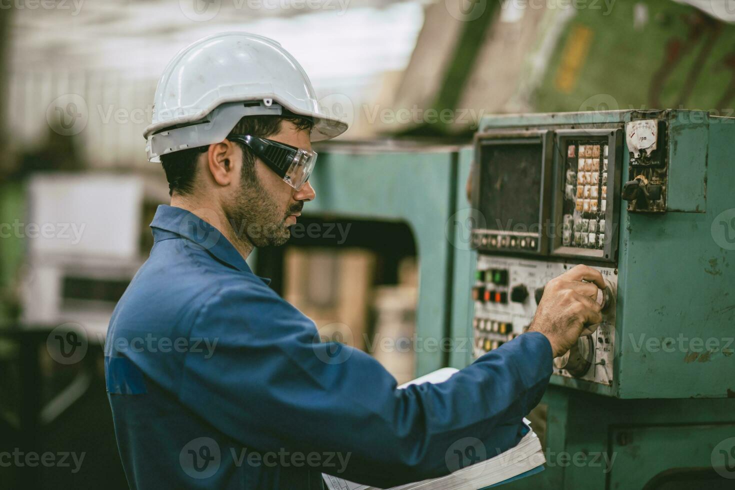Hispano latín indio masculino trabajador trabajando controlar funcionar torno cnc máquina en pesado metal acero fábrica foto