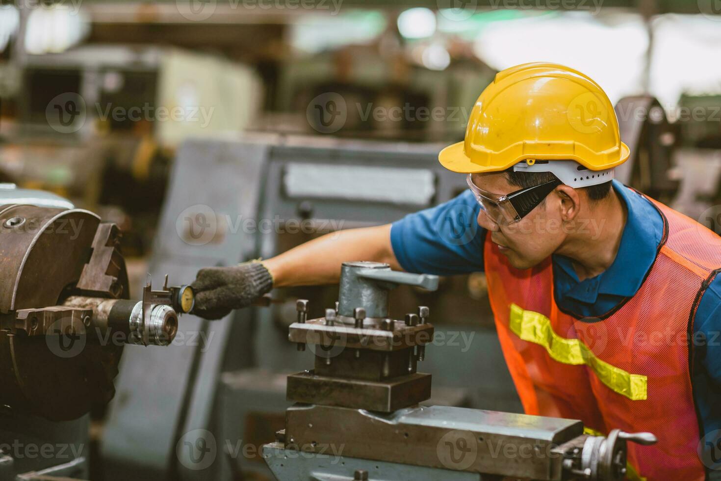 Young Asian Technician Engineer Staff Worker using Lathe CNC Milling Machine work in Heavy Metal Factory. photo