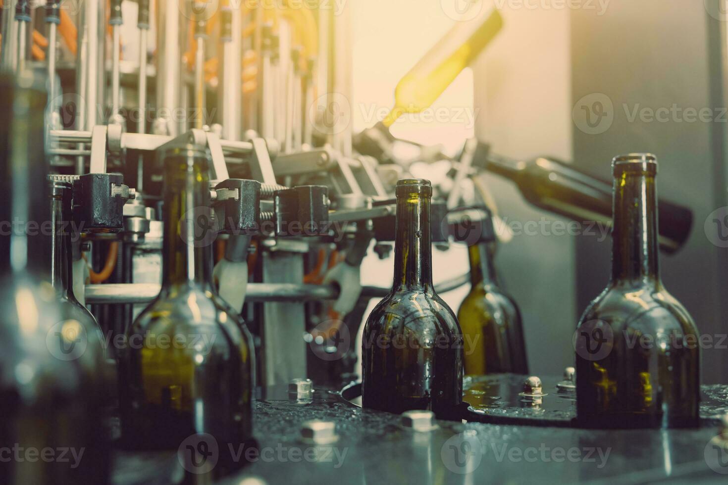 dark wine bottle water injection cleaning machine closeup in operation in winery factory photo