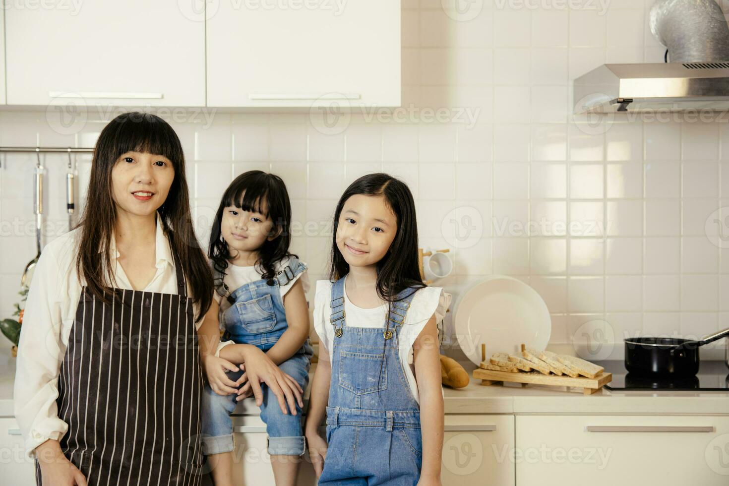 retrato grupo de asiático madre y hija tomando a hogar cocina contento juntos foto