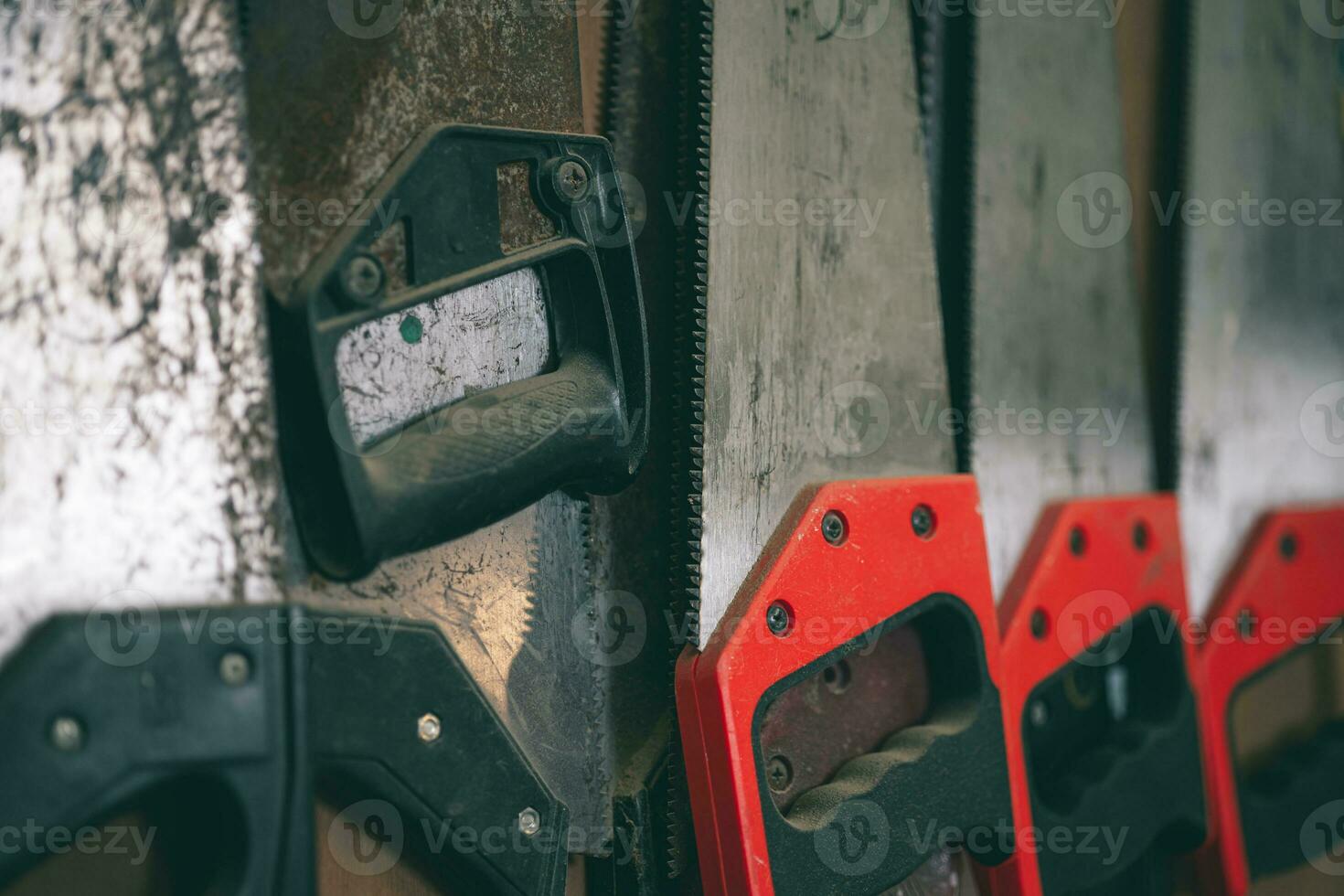 closeup old used rust hand saw sharp teeth for heavy duty wood cut home diy tool hang in workshop. photo