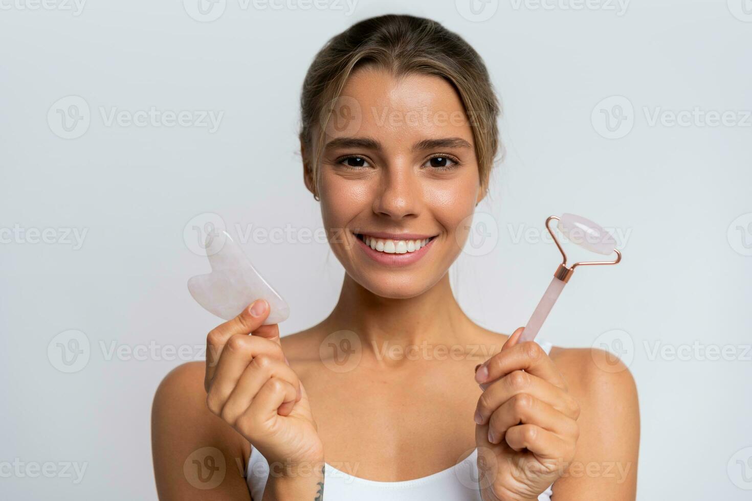 Face massage. Portrait of  beautiful  female fashion model isolated on  white studio background. Blond caucasian woman with healthy well-kept skin. Style and beauty, skin care concept. photo