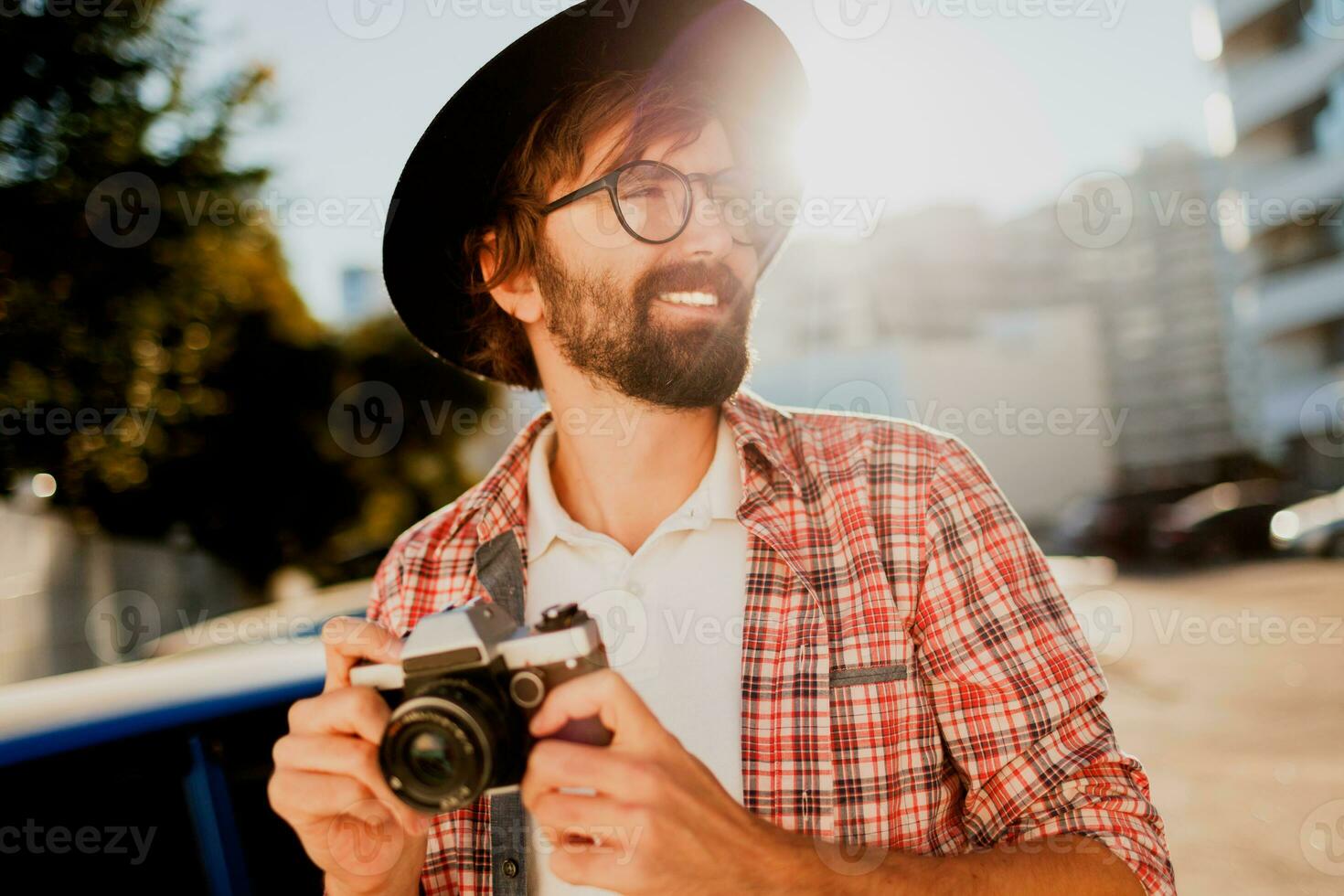 Exited man with beard with interesting using retro film camera , making photos. Tourist mane walking in big modern city. photo