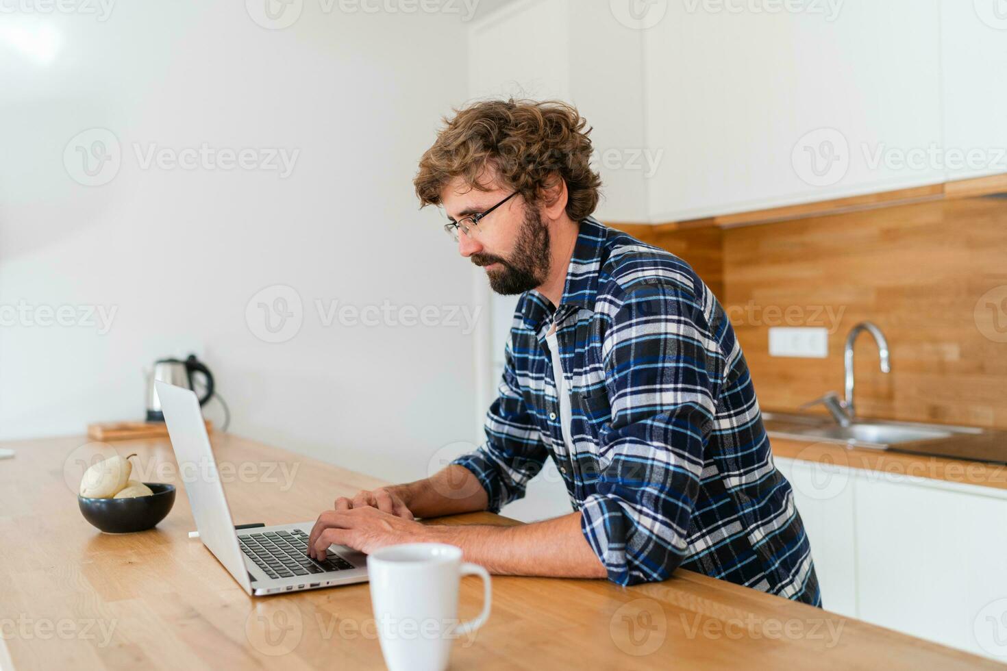 Handsome man freelancer using laptop studying online working from home, happy casual guy typing on pc notebook surfing internet looking at screen enjoying distant job sit at table. photo