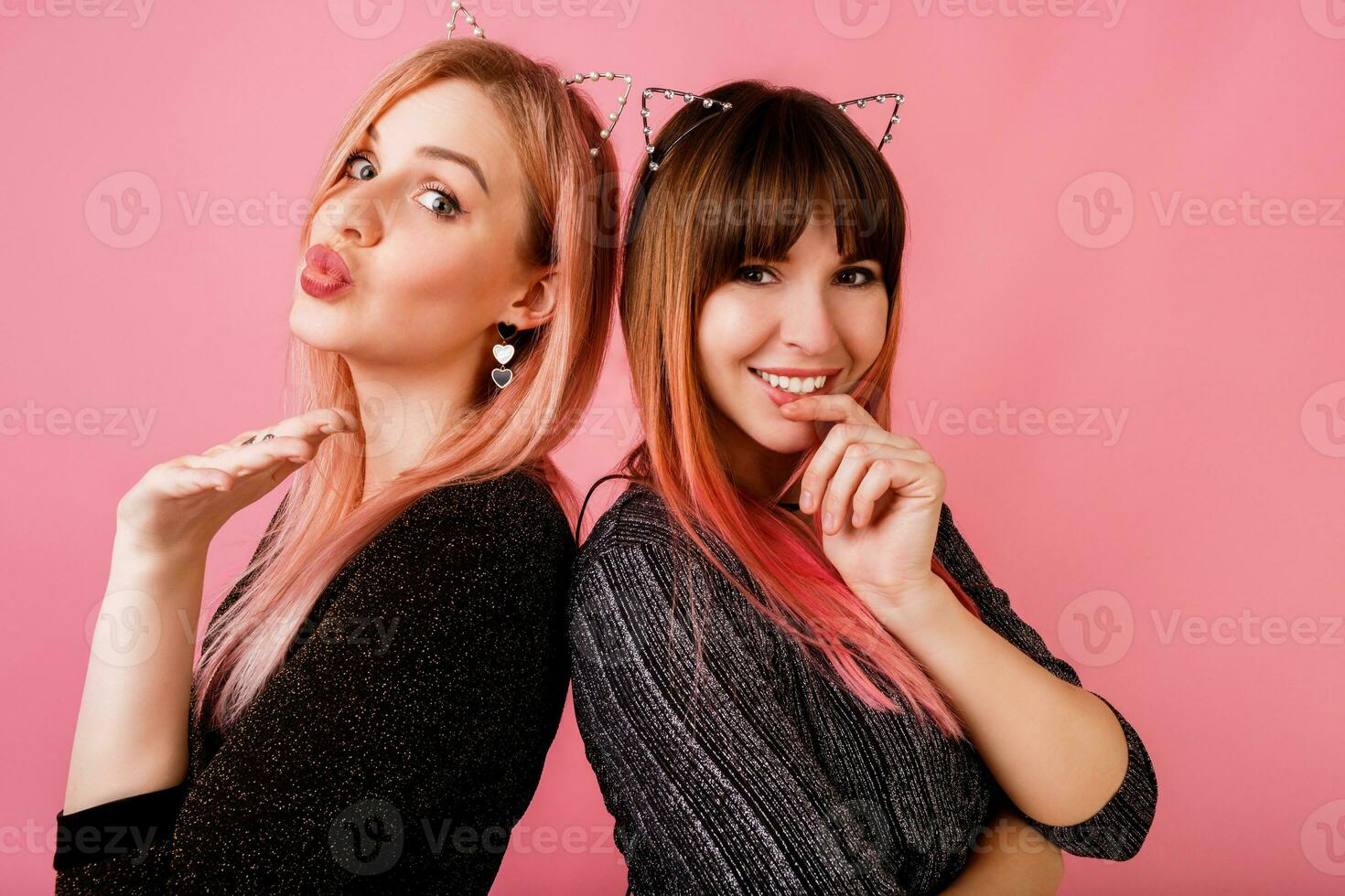Best friends having fun together in studio on pink background photo