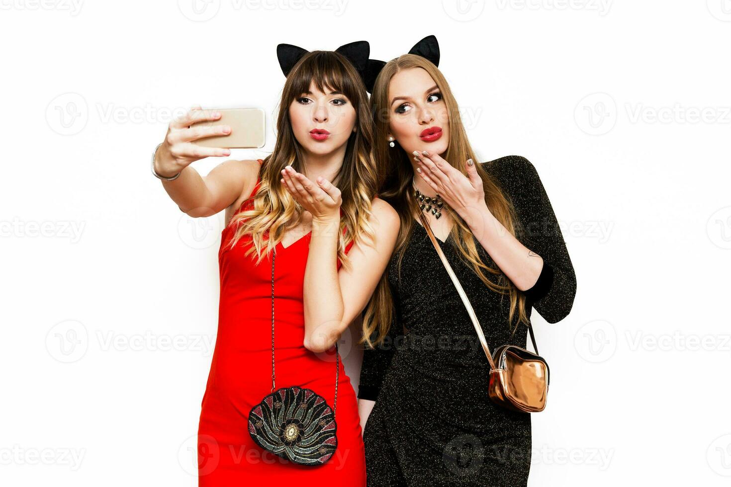 Two women having great time together, making self portrait , use carnival funny paper glasses, wearing elegant evening dress. Friends celebrating new year or birthday party. photo