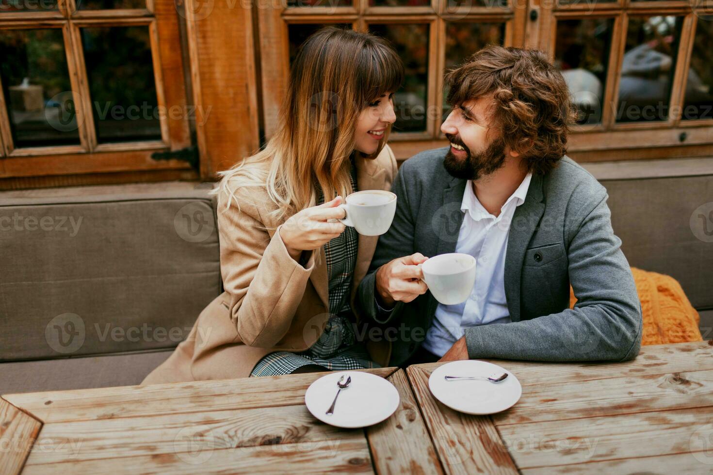 romántico momentos de elegante Pareja en amor sentado en un cafetería, Bebiendo café, teniendo un conversacion y disfrutando el hora gastar con cada otro. foto